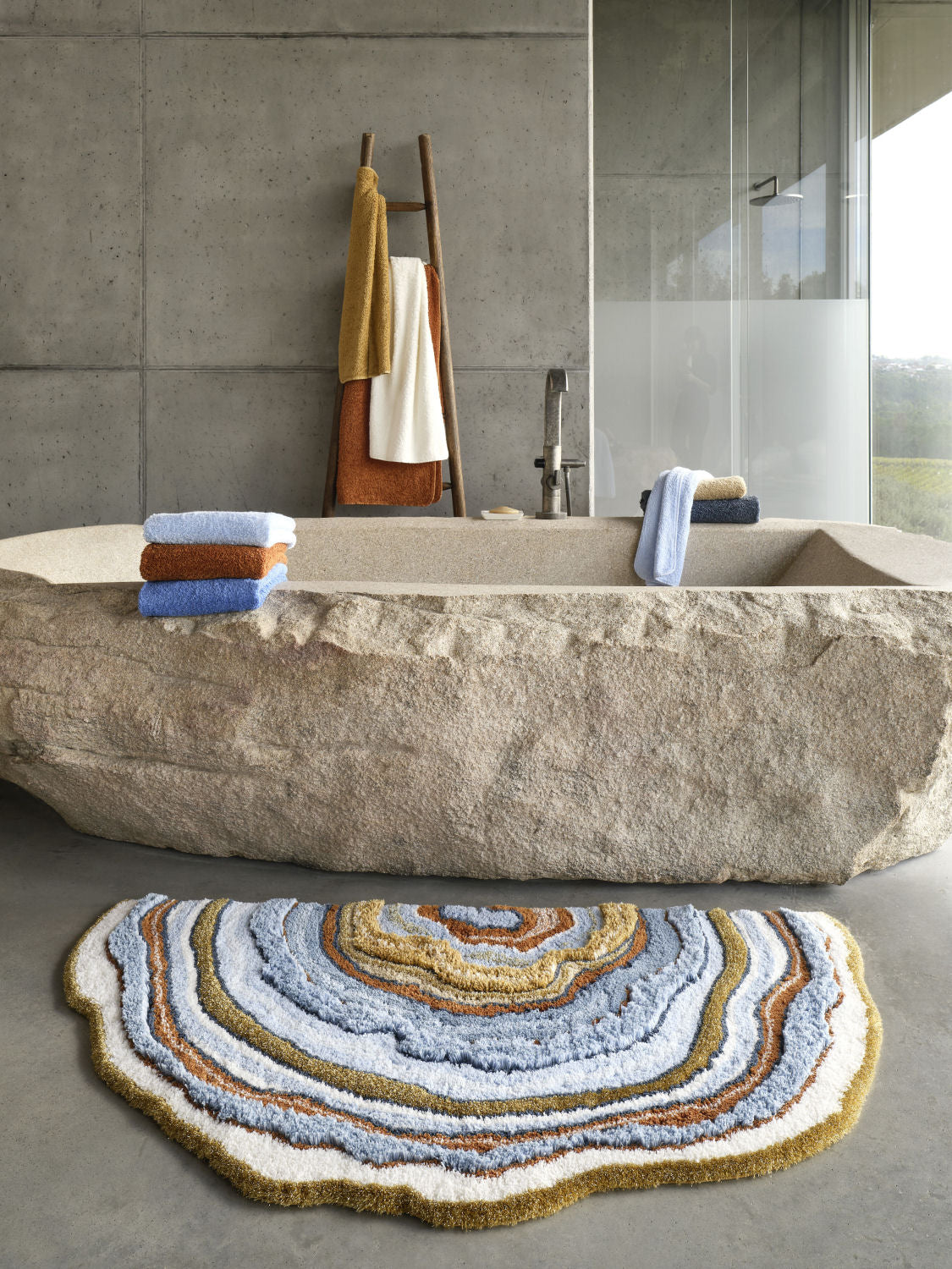 Luxusní designová koupelnová předložka Celora od Abyss & Habidecor v asymetrickém tvaru s modrými, béžovými a zlatými tóny Waterfall Bathrooms
