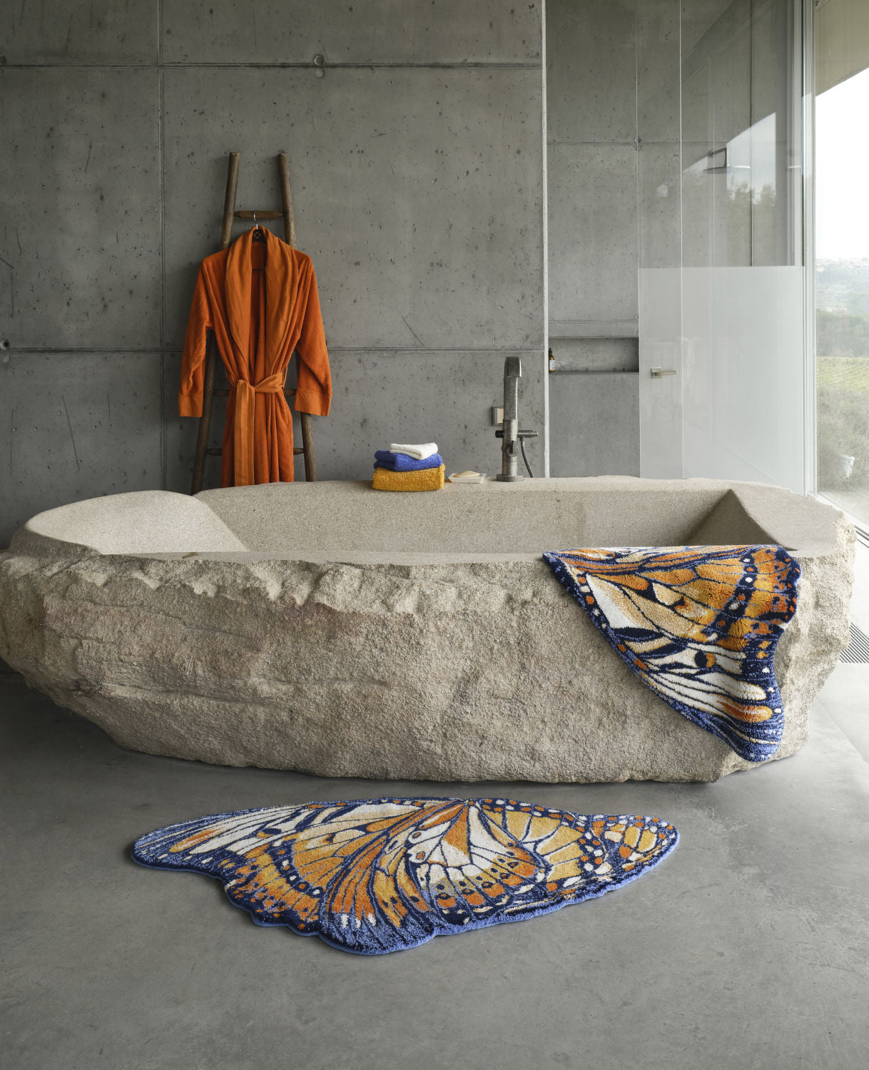 Luxusní koupelnová předložka Mariposa od Abyss & Habidecor ve tvaru detailně vykresleného oranžového a tmavě modrého motýlího křídla Waterfall Bathrooms