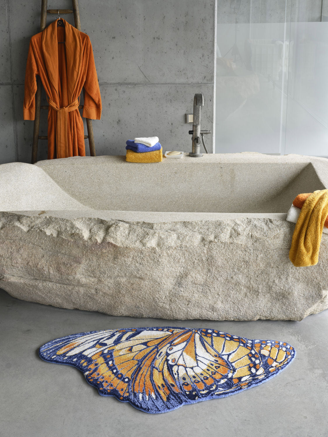 Luxusní koupelnová předložka Mariposa od Abyss & Habidecor ve tvaru detailně vykresleného oranžového a tmavě modrého motýlího křídla Waterfall Bathrooms