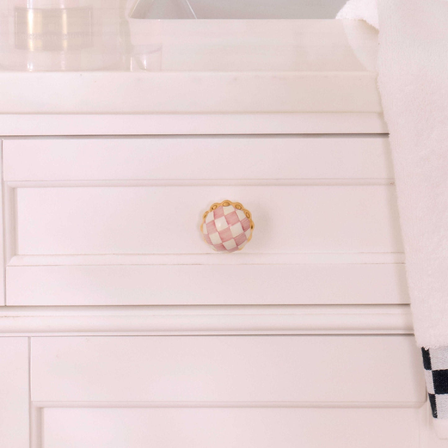 Malá keramická úchytka Rosy Check Petit Four od MACKENZIE-CHILDS, ručně malované růžovo-bílé kostičky, zvlněný okraj, zlaté akcenty, Waterfall Bathrooms.
